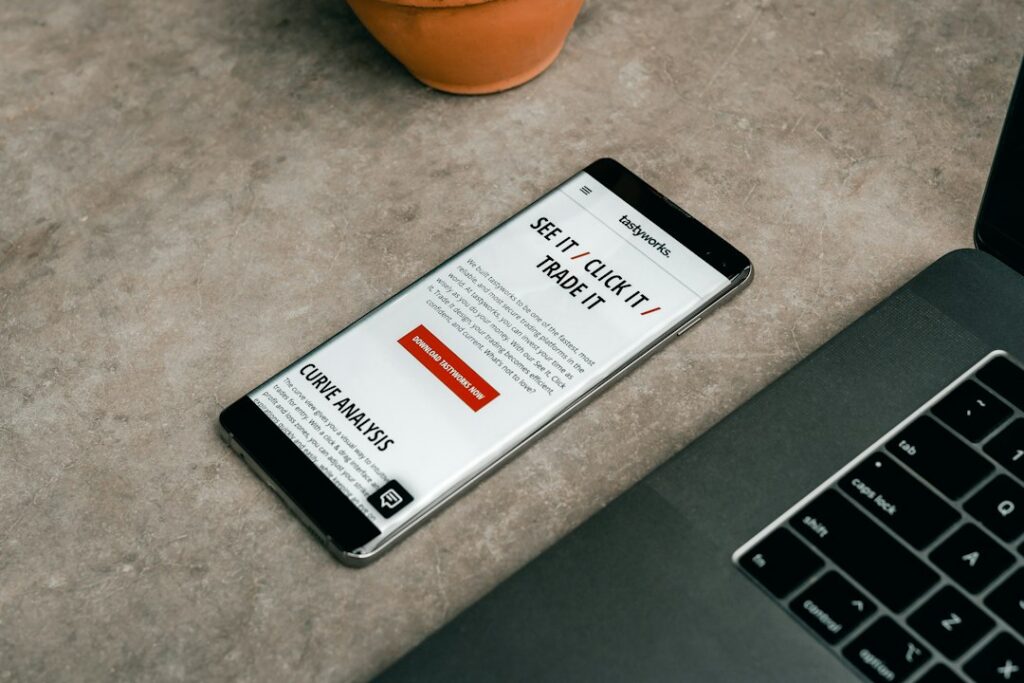 Person reviewing a clean email newsletter layout on a laptop beside a smartphone and handwritten notes